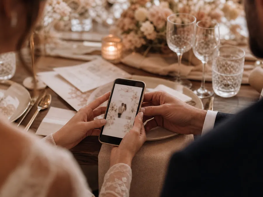 Pareja revisando una invitación digital durante una boda